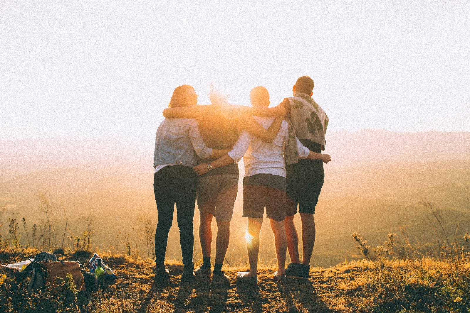 Friends standing together on a hilltop at sunrise, a picture of shared hope and renewal